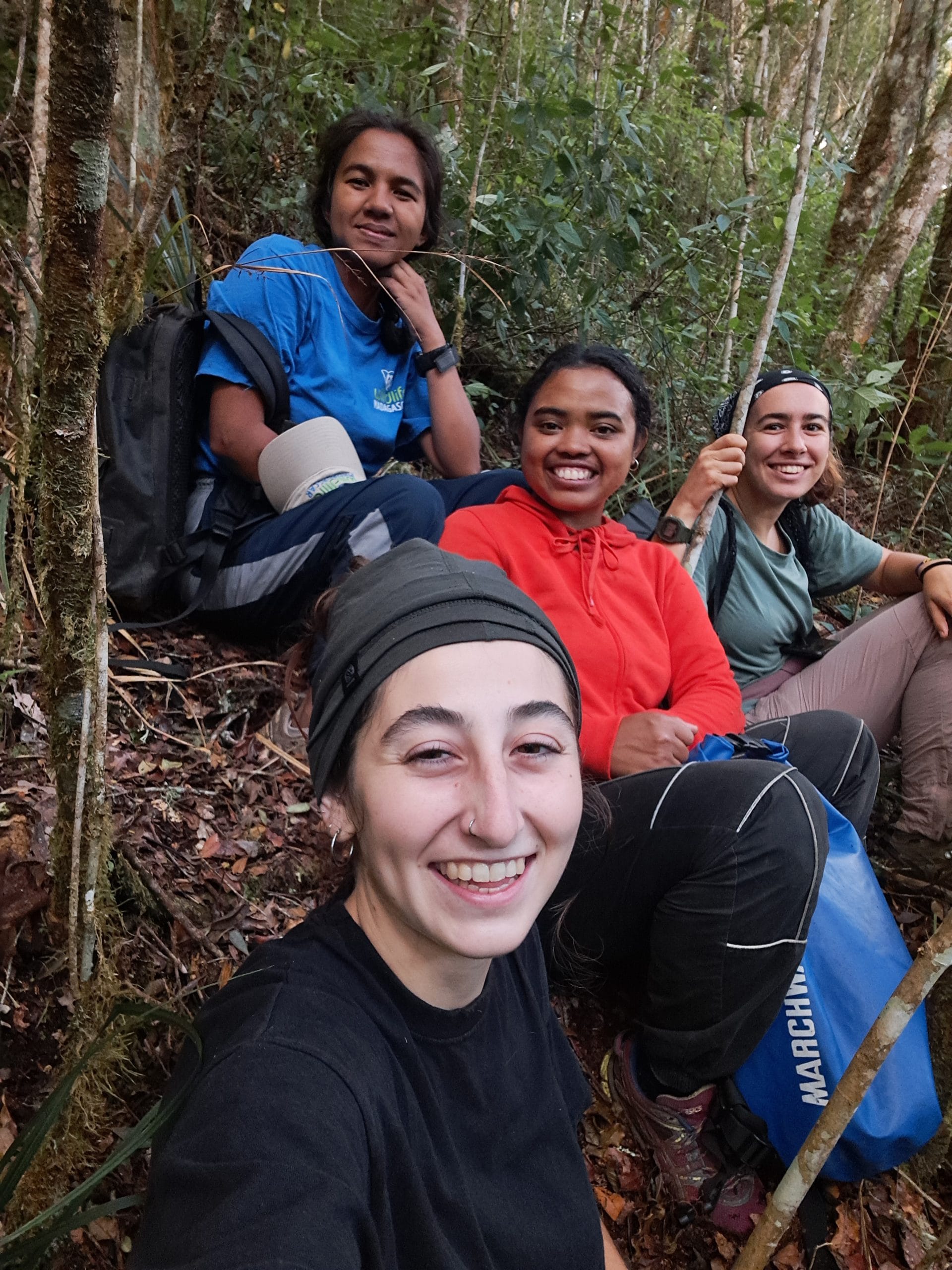 4 women researchers sitting in the Madagascar rainforest